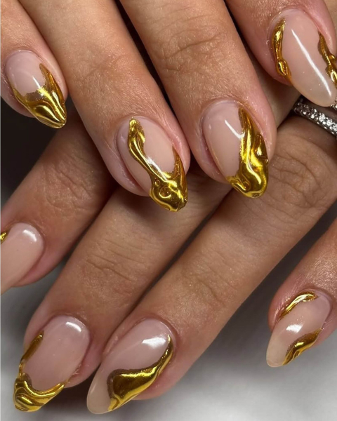 Nude almondshaped nails with raised yellow gold drip design.